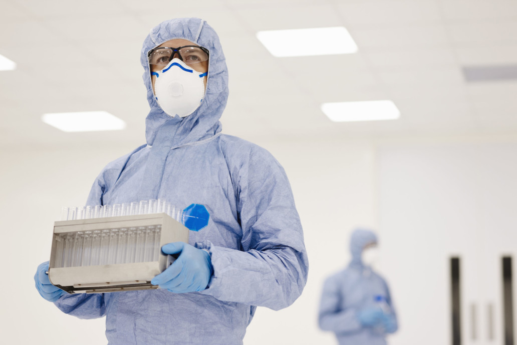 ACE - Scientist carrying tray of test tubes in laboratory